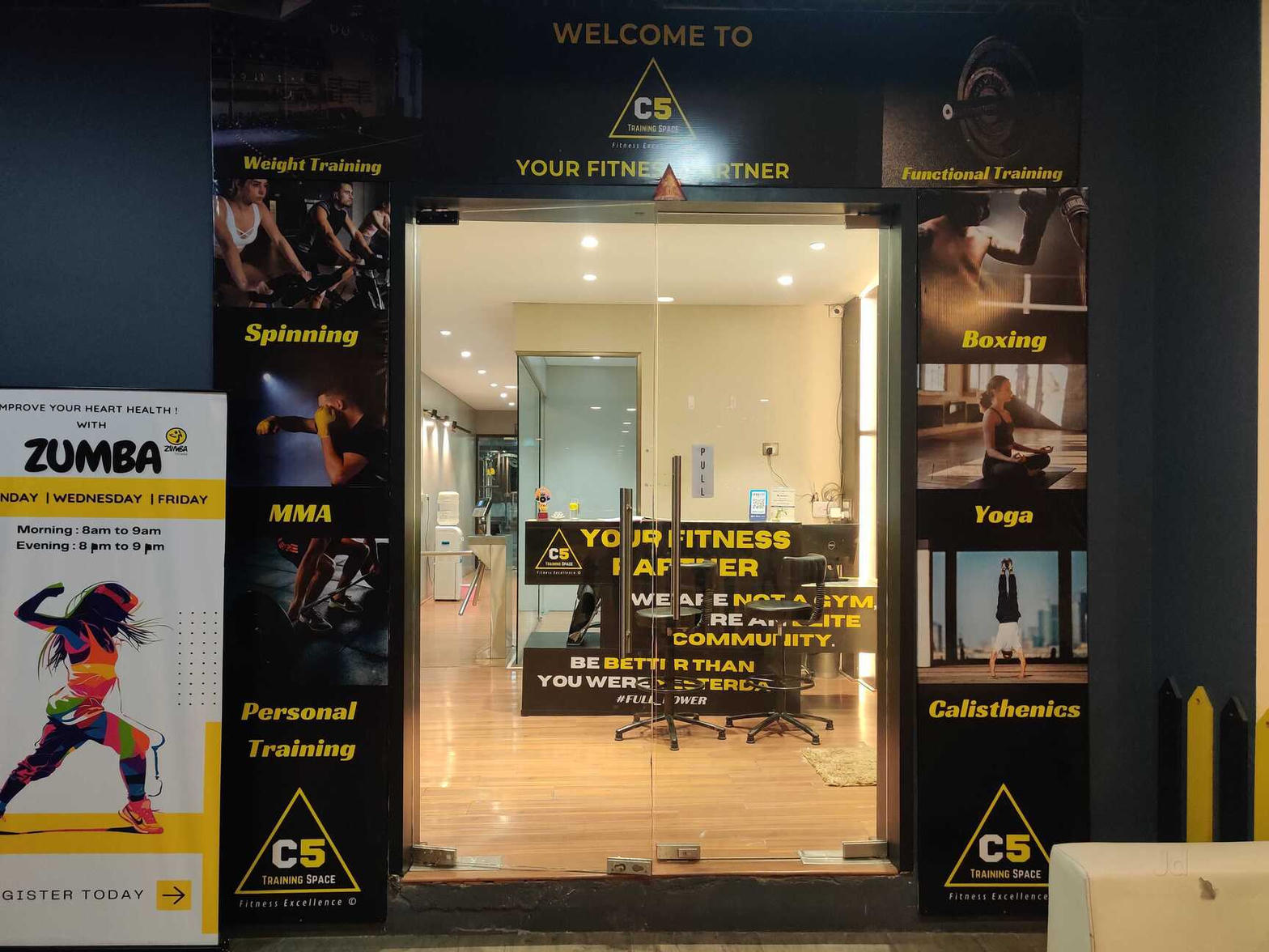 Entrance of C5 Training Space at Xion Mall Hinjewadi showing yellow and black branding for gym, MMA, Zumba, yoga and calisthenics