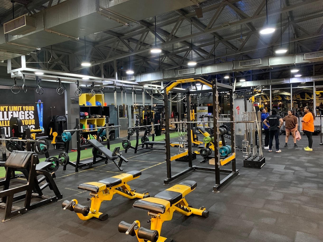 Yellow and black strength equipment, benches and squat rack on the C5 Training Space gym floor in Hinjewadi